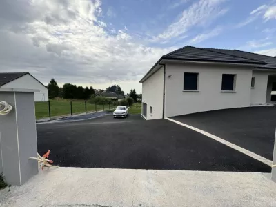 Enrobé à chaud  noir avec mise en place d’une bande de pavés collés beige sur la commune de USSEL (19)